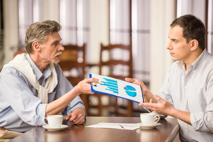 Pearl Lemon team members discussing sales data over coffee during a strategy meeting.